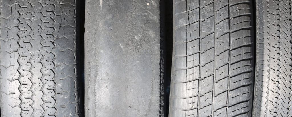 worn out bald old car tire close-up | Rad Air Complete Car Care worn tires