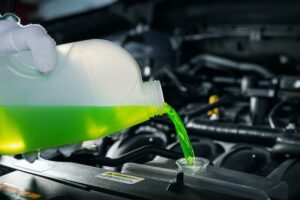 pouring antifreeze coolant liquid into car engine radiator | Rad Air Complete Car Care pouring antifreeze coolant liquid into car engine radiator