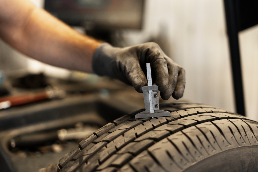 Mechanic measuring tyre tread depth using caliper | Rad Air Complete Car Care Mechanic measuring tire tread depth using caliper